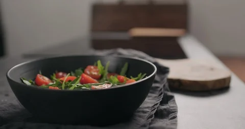 Slow motion man hands put pesto sauce on cherry tomatoes and fresh arugula in Stock Footage 128673378
