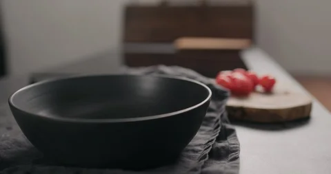 Slow motion man hands put arugula in black bowl on concrete countertop Stock Footage 128673401