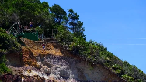 Slow motion of man having fun at zipline, sliding from the lighthouse hill Video stock 142463430