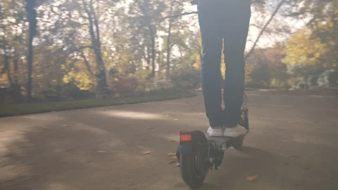 Slow Motion of Man with Helmet Using Electric Scooter in Sunny Park 4 Vidéo 98757493