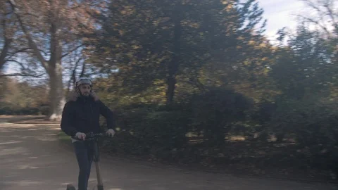 Slow Motion of Man with Helmet Using Electric Scooter in Sunny Park 6 Vidéo 98757511