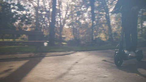 Slow Motion of Man with Helmet Using Electric Scooter in Sunny Park 7 Vidéo 98757597