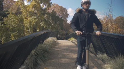 Slow Motion of Man with Helmet Using Electric Scooter on a Bridge 1 Vidéo 98758394