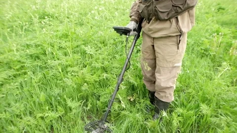 Slow-motion. A man holds a device, a metal detector in his hand, works in a Stock Footage 156400622