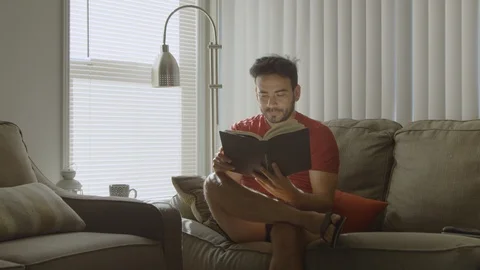 Slow motion of man at home closing a book and reflecting on it Stock Footage 114644589