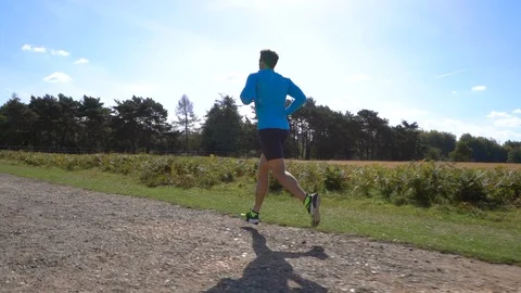 Slow Motion Man Jogging from Side View with Sun in Background Stock Footage 96048084