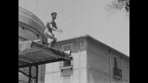 Slow motion of a man jumping into a pool, united kingdom, 1932 to 1936 Stock Footage 131531221