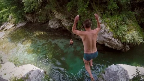 Slow motion of man jumping from rock into river, Slovenia. Stock Footage 97111977