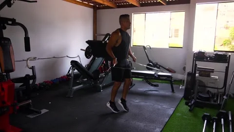 Slow motion of a man jumping rope in his personal home gym Stock Footage 146506648