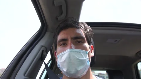 Slow motion of a man looking at the camera in a car wearing a mask Stockbeeldmateriaal 150917618