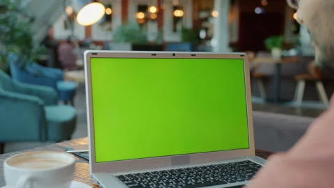 Slow motion of man looking at green screen chroma key green screen in cafe Stock Footage 165612800