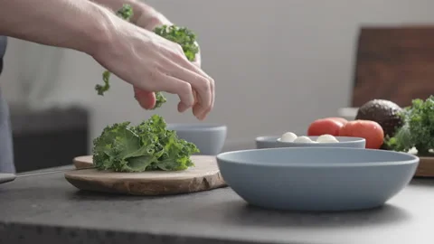 Slow motion man make salad with kale, mozzarella, avocado and cherry tomatoes Stock Footage 147972500