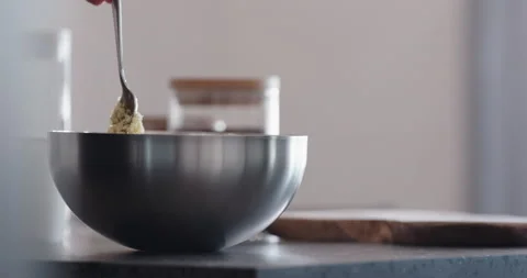 Slow motion man making granola mix cereal flakes in steel bowl on kitchen Vidéo 196965972