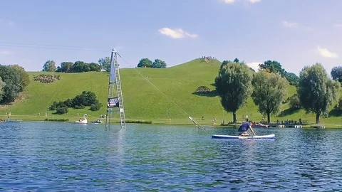 Slow motion of man paddle boarding on the calm lake in summer, Munich Stock Footage 106598026