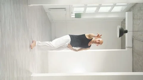 Slow motion of a man performing elements of modern dance in a bright studio Stock Footage 159856186