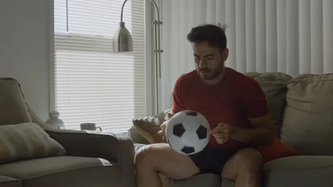 Slow motion of man playing with soccer ball at home gets up and leaves Stock Footage 114645259