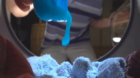 Slow motion – Man pouring laundry detergent into a washing machine. Stock-Footage 100587387