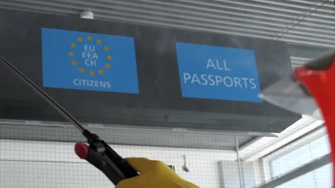 Slow Motion Man In Protective Suit Disinfecting Passport Control Area Vídeos de archivo 130277690