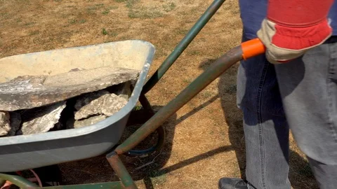 Slow motion: Man pushing a loaded wheelbarrow. Video stock 92198732