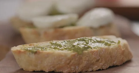 Slow motion man put mozzarella slices on ciabatta slice with pesto on olive Video stock 132034288