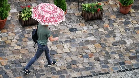 Slow motion of man with rain umbrella at old town market square, Lviv Ukraine Stock Footage 112627482