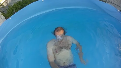 Slow motion of man recording him self in swimming pool slowly going underwater Stock Footage 127239709