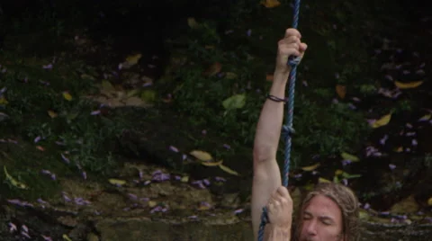 Slow Motion Man on Rope Swing in Jungle Lagoon Stock Footage 68189072
