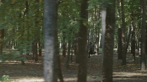 Slow motion man running between trees Stock Footage 220029153