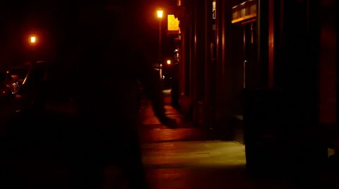 Slow motion of a man running on a dark sidewalk to escape from followers Vidéo 59938988
