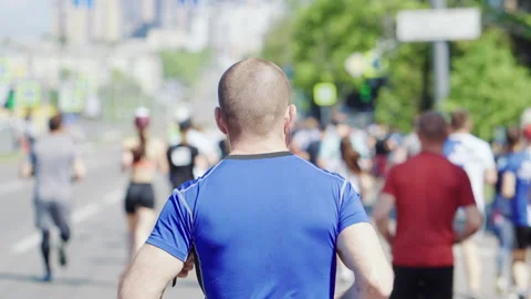 Slow motion man running marathon in city Stock Footage 154235442