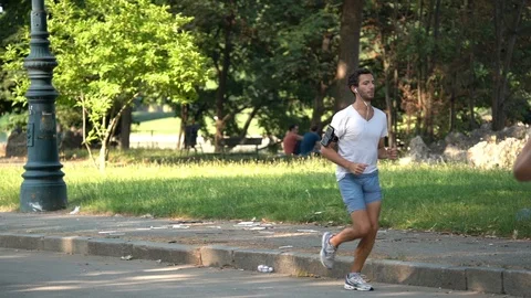 Slow Motion of a man running in the park Stock Footage 111877780