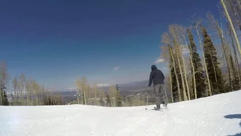 Slow motion of man skiing on bright day at Utah mountain ski resort Stock Footage