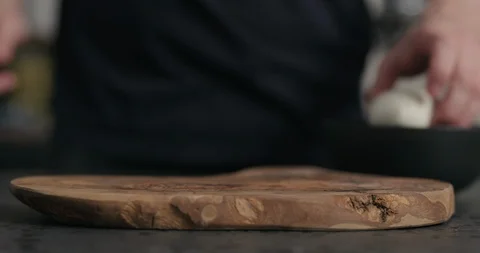 Slow motion man slicing fresh mozzarella cheese on olive wood board Stock Footage 124375509