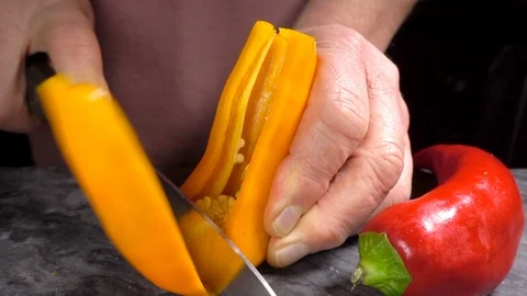 Slow motion – Man slicing a sweet yellow pepper with a large knife. Vídeos de archivo 107660962