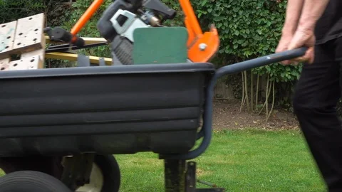 Slow motion - Man slowly pushing a large wheelborrow full of heavy equipment. Stock-Footage 112783543