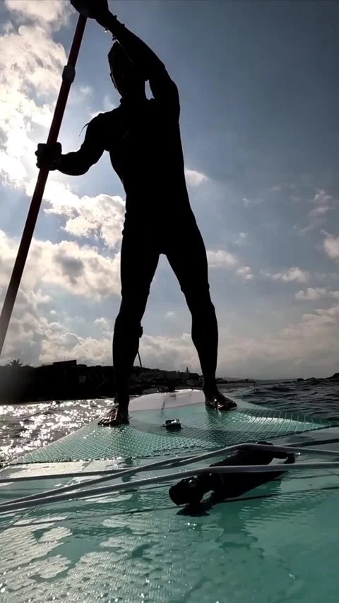 Slow motion man on stand up paddle board seen against sun Stock Footage 310212372