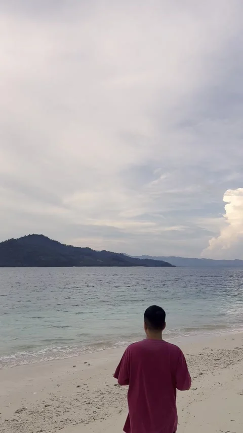 Slow Motion of Man Standing on Beach Overlooking Ocean Stock Footage 340381229