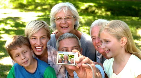 In slow motion man taking picture of his cheerful extended family Stock Footage 47540500