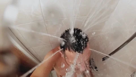 Slow motion , man taking a shower in the bathroom. View from a shower head Video stock 135462563