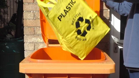 Slow Motion - Man tipping plastic waste from recycle carrier into recycling bin. Video stock 110298604