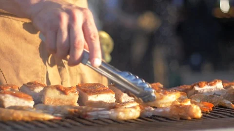Slow motion man turning slice of pork belly on grill Video stock 96312645