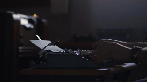 Slow motion of a man typing at a typewriter, pulls the paper out to check Stock Footage 97856812