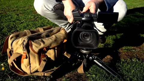 Slow motion: Man using a professional camcorder outside. Video stock 97219293