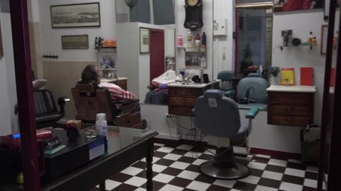 Slow motion of a man waiting to get a shave at an old barbershop Stock Footage 141383892