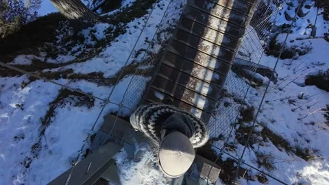 Slow motion man Walking Across Suspension Bridge Over River in Snowy Alps Stock-Footage 326180638