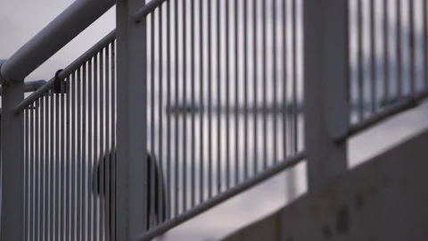 Slow Motion Of A Man Walking Behind A Road Railing Stock Footage 127100105