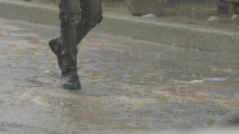 Slow motion man walking down the street during heavy rain Stock Footage 318084020