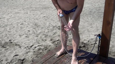 Slow motion a man washes his feet in the shower at the beach Stock Footage 112368134