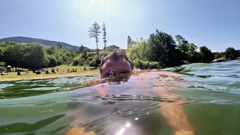 Slow-motion of a man who dives into Lake Serraia and returns to the surface Stock Footage 340185208