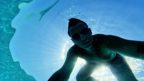Slow-motion of a man who free-dives into the sea and begins swimming underwater Stock Footage 339055572